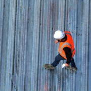 Worker inspecting metal roof