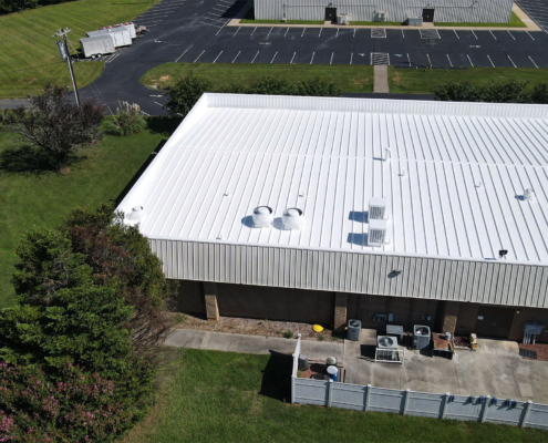 Aerial view of a building with a white metal roof