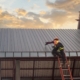 Construciton worker installing metal roof on commercial building